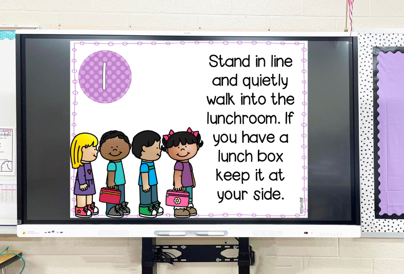 kids standing in line at lunch with a daily routines for kindergarten google slide on the smartboard