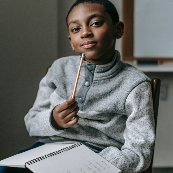 early finisher activities- little boy sitting with a notebook and pencil