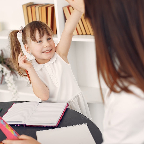 little girl with notebook high fiving teacher