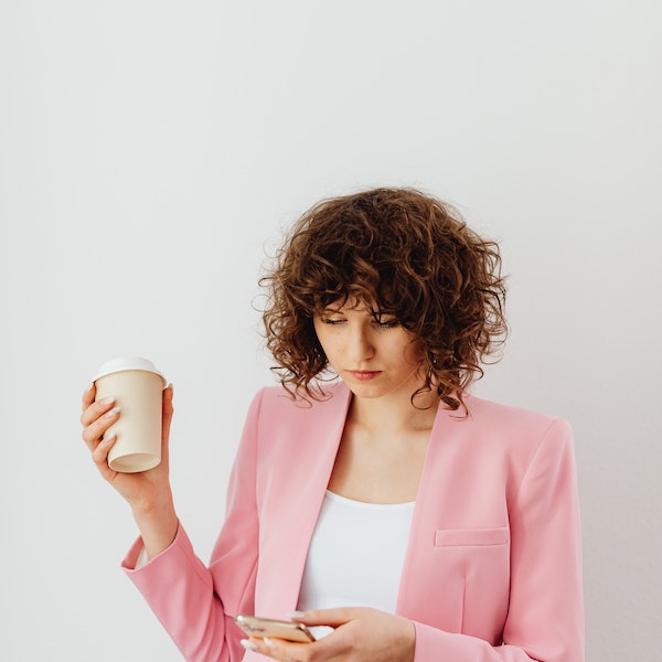 woman with coffee texting