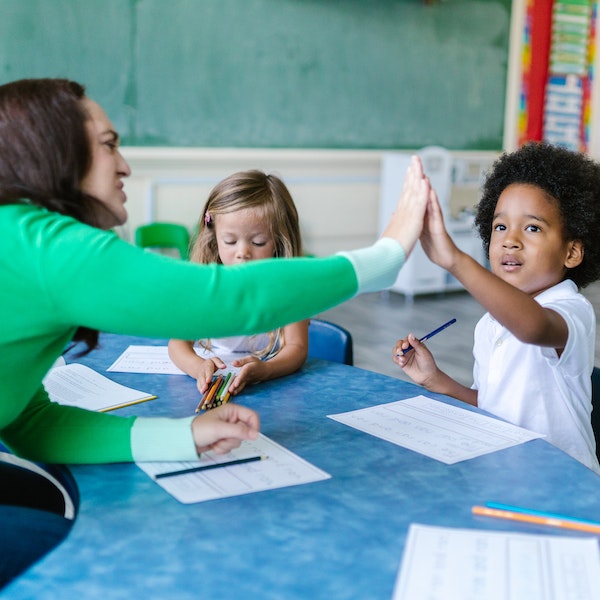 teacher high fiving a child in small group 